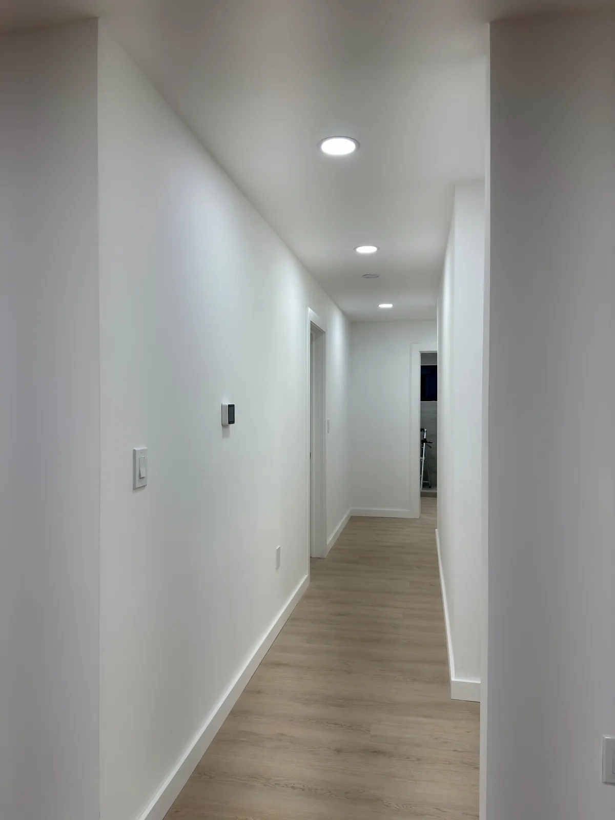 Finished hallway after whole-home finishing, smooth walls and new floor