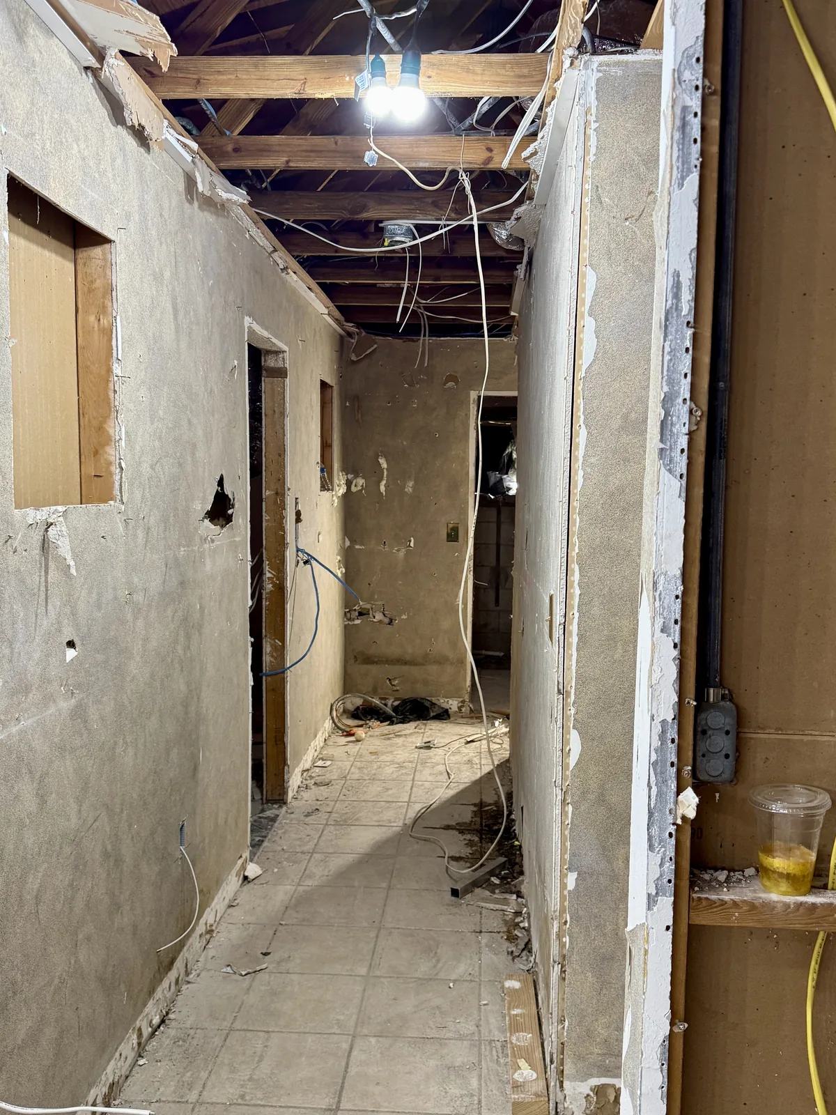 Hallway gutted to the studs before whole-home finishing work